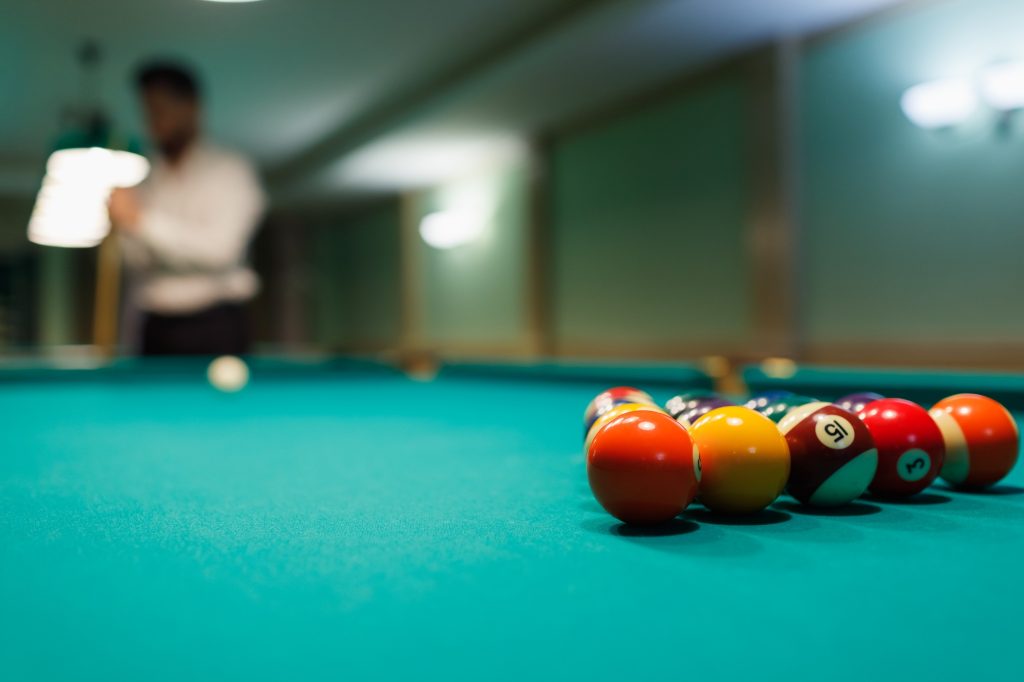 Billiard player at billard table or snooker american billiards pool sport game